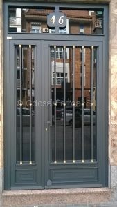Portal de forja de tubo redondo con macollas de latón